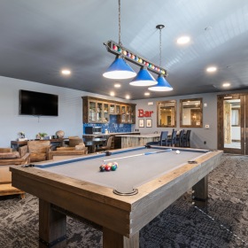 Large game room with a pool table and plenty of seating 
