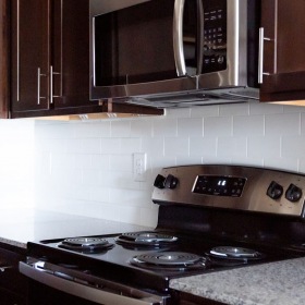 Kitchen kitchen area on wooden floor with spacious counter-space and designer appliances