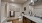 Large well lit bathroom with large mirror and brown cabinets 